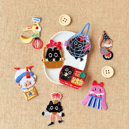 Majiang the Black Cat embroidered patches: the full series of eight around a white plate with buttons