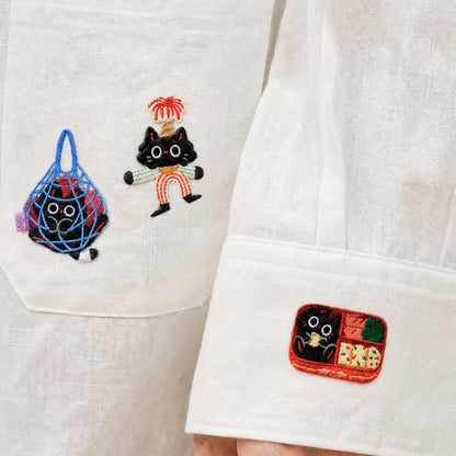 Majiang patches ironed onto the pocket and cuff of a white shirt